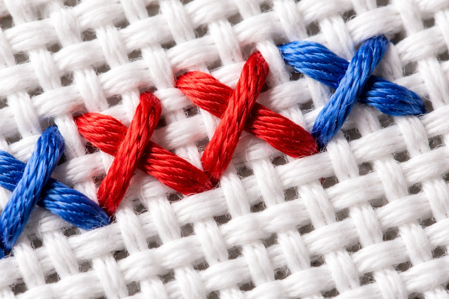 Aida kumaş üzerinde yakından çekilmiş çapraz dikiş detayı